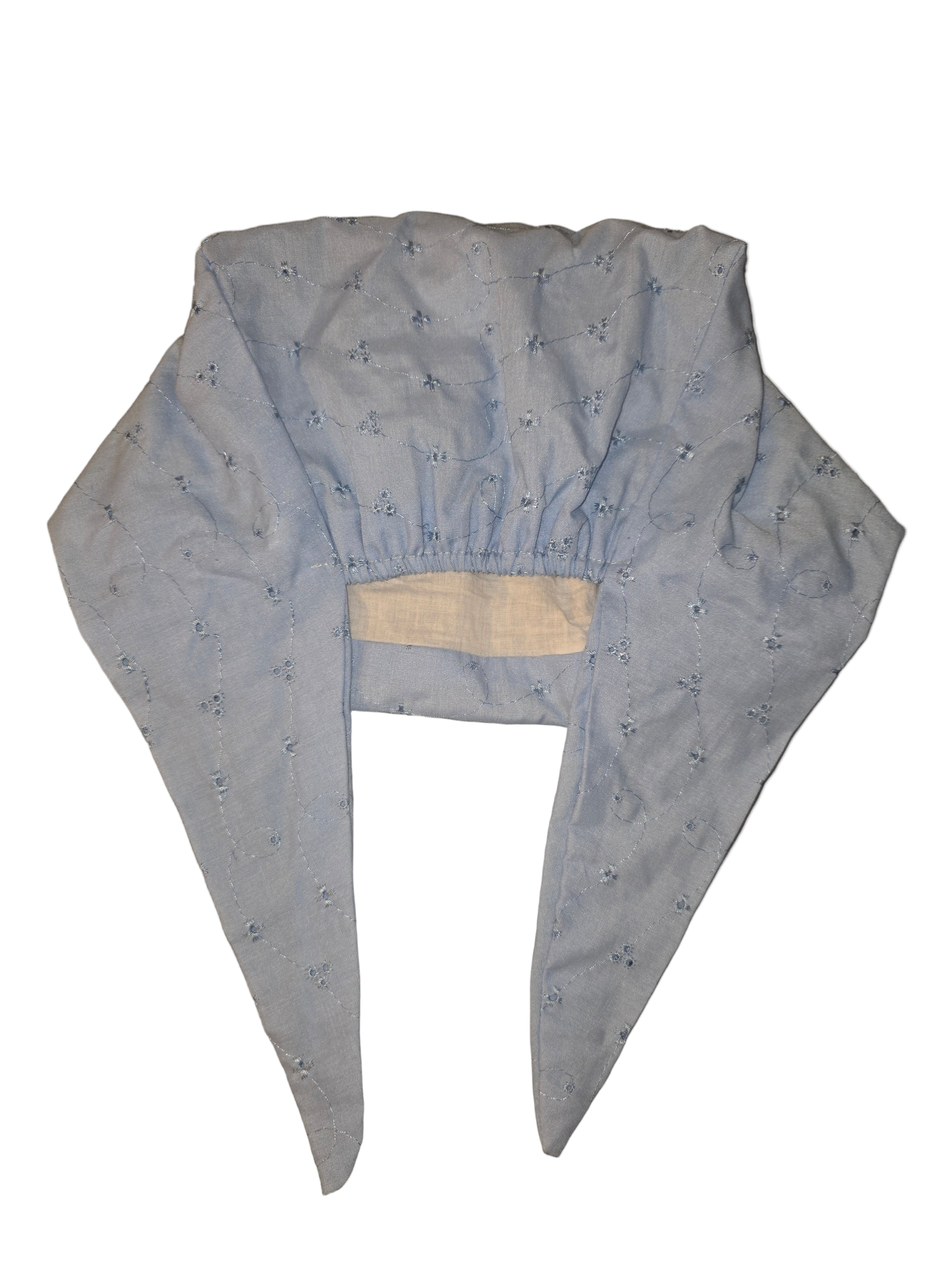 Light blue baby outfit with a hood on a reflective surface