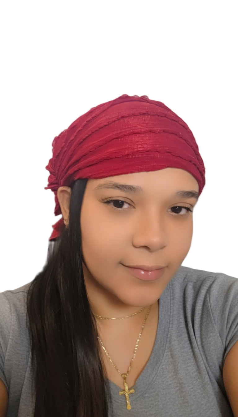 Woman wearing a red headscarf with a neutral background